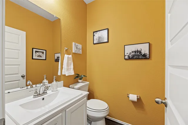 a bathroom with a sink mirror and toilet