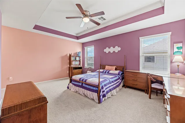 a bedroom with a bed and a ceiling fan