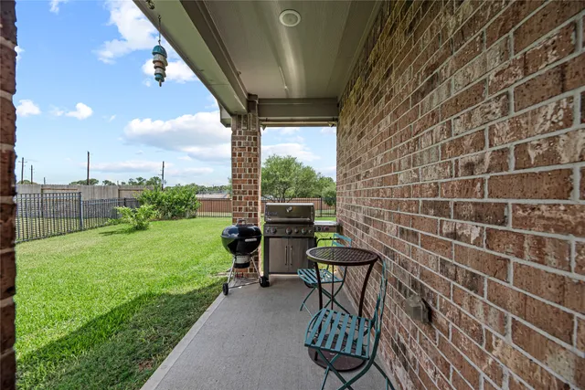 a view of a chairs and table in patio with a yard
