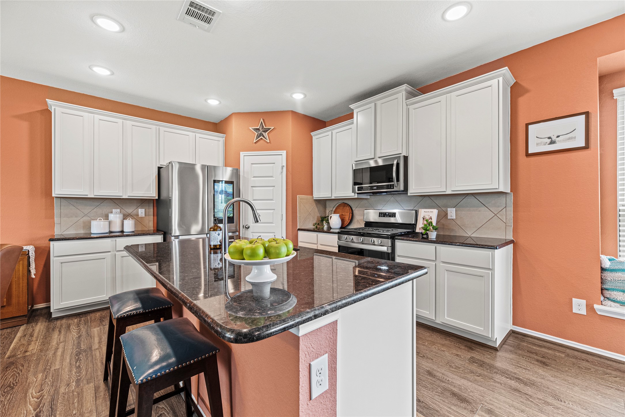 32963 Ruthie Dean Drive Fulshear, TX 77423 - Photo 9 of 45 a kitchen with stainless steel appliances granite countertop a sink a stove a refrigerator cabinets and wooden floor