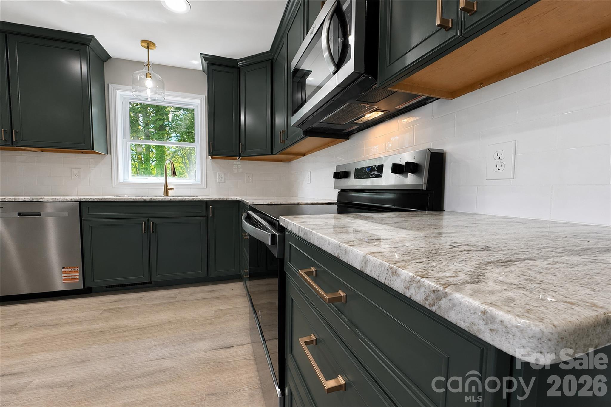 1403 Dudley Shoals Road Granite Falls, NC 28630 - Photo 5 of 34 a kitchen with stainless steel appliances granite countertop a sink and stove