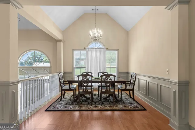 a view of a dining room and livingroom with furniture wooden floor a chandelier