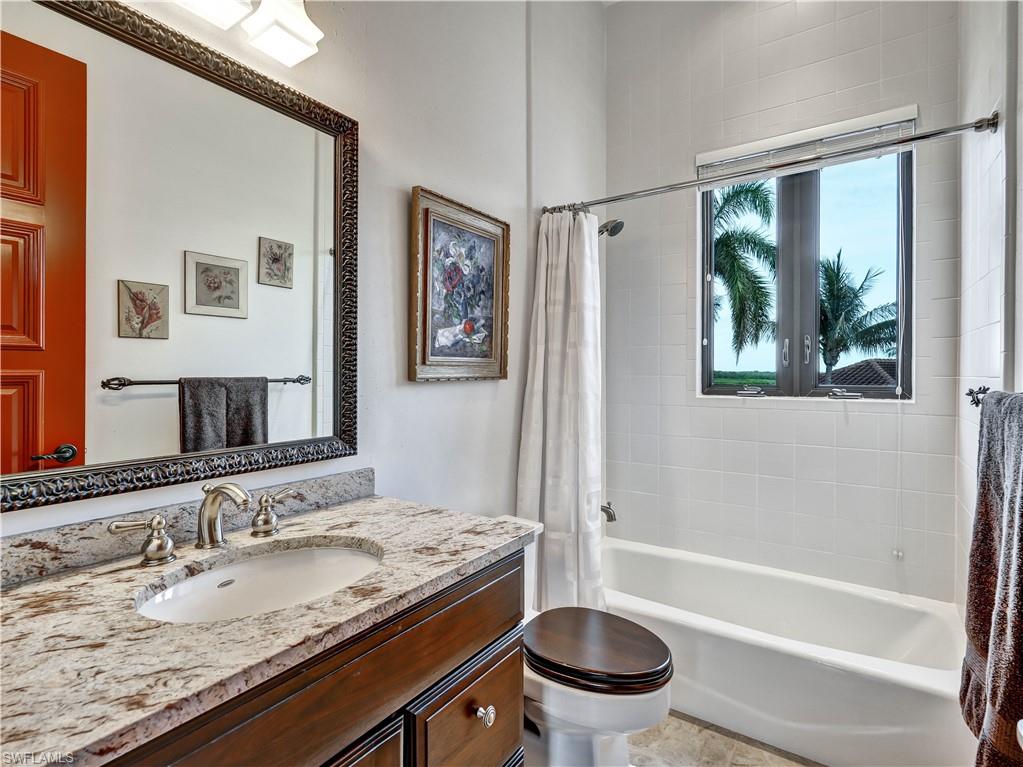 2535 Tarpon Road Naples, FL 34102 - Photo 31 of 50 Bathroom featuring a vanity with a granite-style countertop, undermount sink, and brushed nickel fixtures