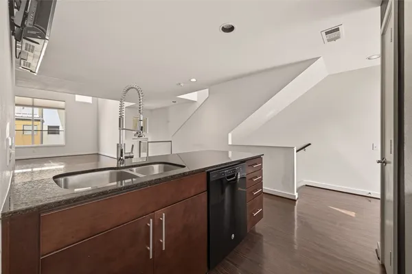 a kitchen with stainless steel appliances granite countertop a sink and a refrigerator