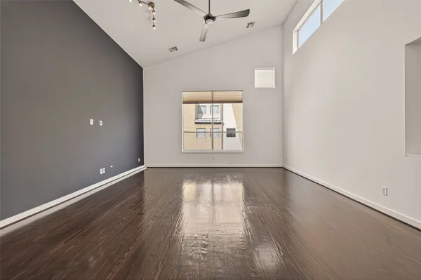an empty room with wooden floor and windows