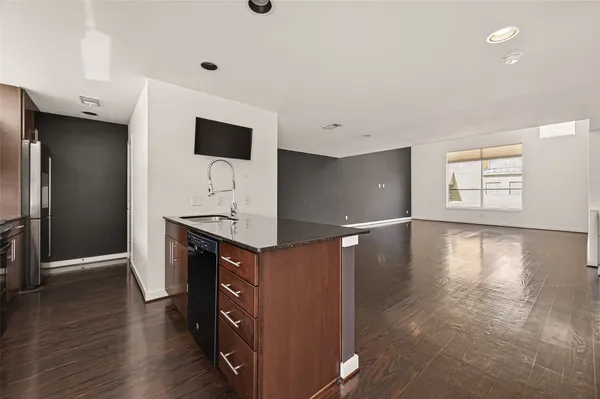 a kitchen with stainless steel appliances a refrigerator and wooden floor