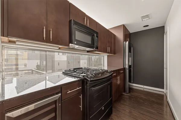 a kitchen with stainless steel appliances granite countertop a stove and a microwave