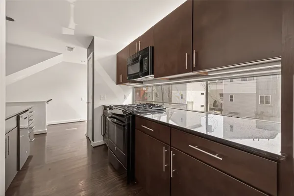 a kitchen with stainless steel appliances granite countertop a sink and a stove top oven