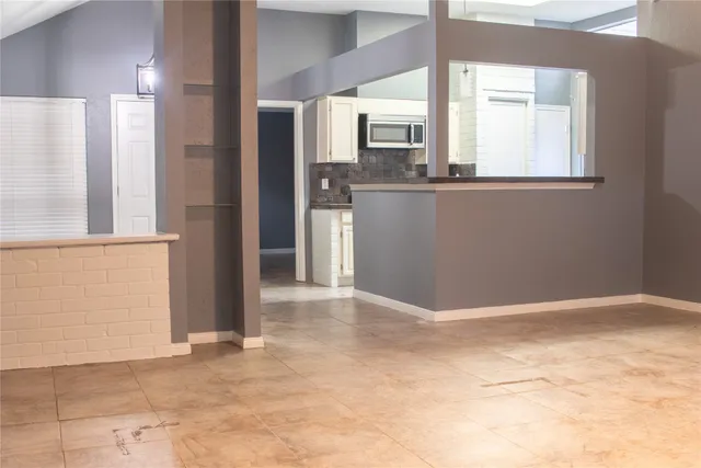 a view of a kitchen with wooden floor and a window