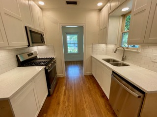 1305 East 28th Street, Unit A Austin, TX 78722 - Photo 11 of 15 Kitchen with stainless steel appliances, tasteful backsplash, light wood-style floors, and recessed lighting