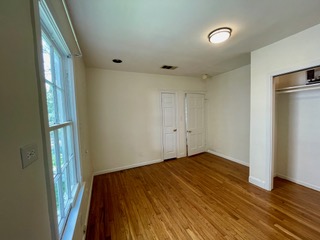 1305 East 28th Street, Unit A Austin, TX 78722 - Photo 13 of 15 Unfurnished bedroom featuring wood finished floors and a closet