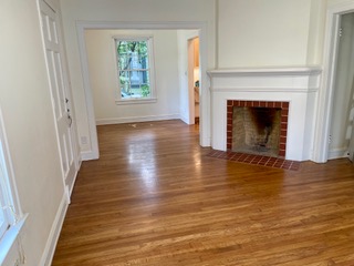 1305 East 28th Street, Unit A Austin, TX 78722 - Photo 4 of 15 Unfurnished living room featuring dark wood-style flooring and a brick fireplace