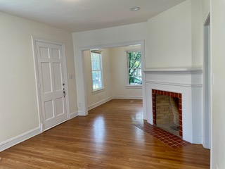 1305 East 28th Street, Unit A Austin, TX 78722 - Photo 5 of 15 Unfurnished living room with light wood-style flooring and a fireplace