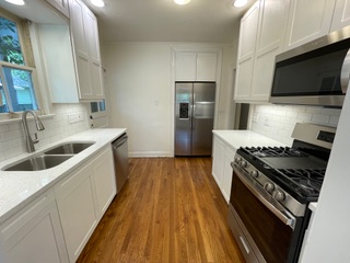 1305 East 28th Street, Unit A Austin, TX 78722 - Photo 10 of 15 Kitchen featuring stainless steel appliances, white cabinets, recessed lighting, decorative backsplash, and dark wood-style floors