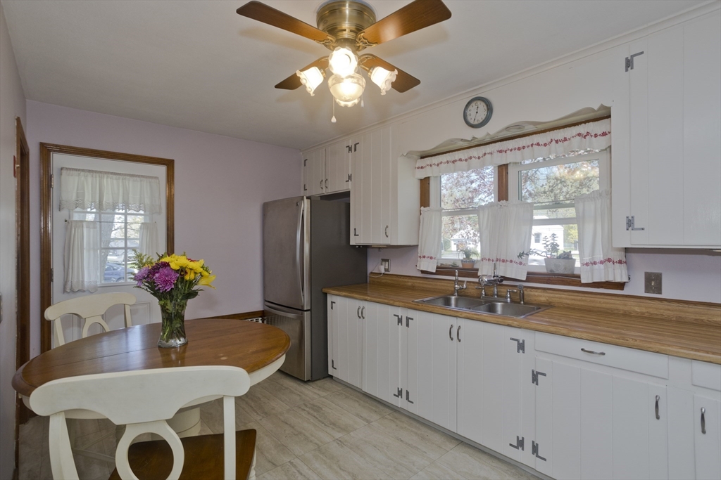 460 James Street Chicopee, MA 01020 - Photo 6 of 34 a kitchen with stainless steel appliances granite countertop a sink dishwasher a dining table and chairs with wooden floor