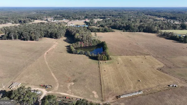 an aerial view of a house with a yard and lake view