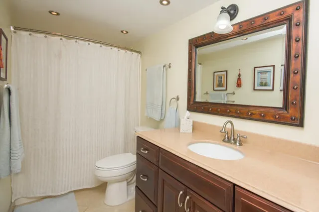 a bathroom with a granite countertop sink toilet and shower