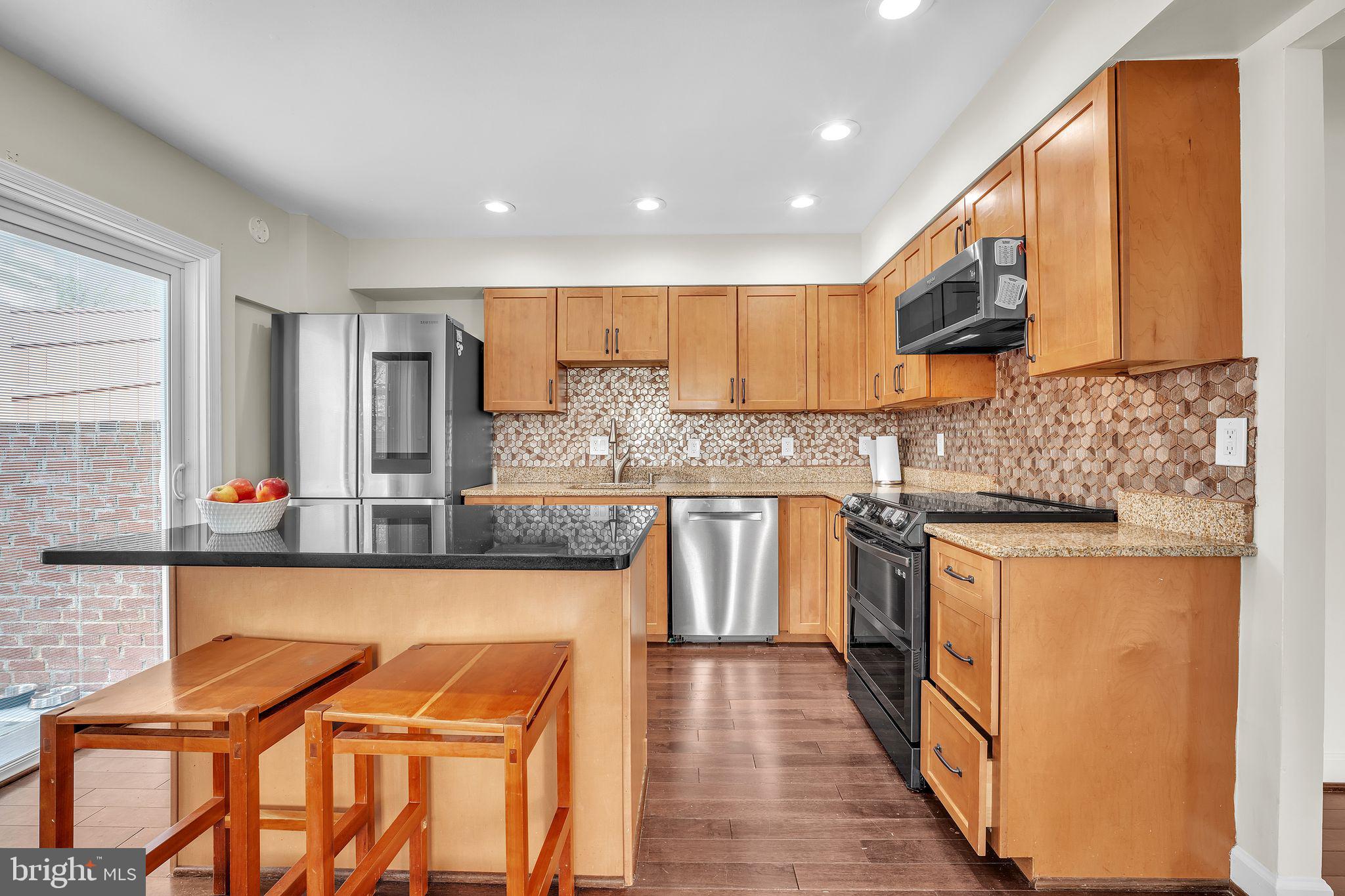 5255 Pumphrey Drive Fairfax, VA 22032 - Photo 10 of 38 a kitchen with stainless steel appliances granite countertop wooden cabinets a stove top oven a sink and dishwasher