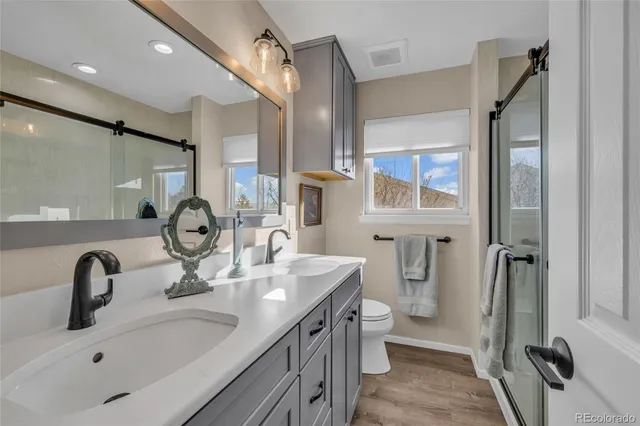 a bathroom with a double vanity sink a toilet and a mirror