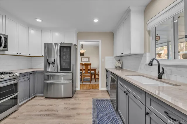a kitchen with stainless steel appliances granite countertop a refrigerator stove and sink