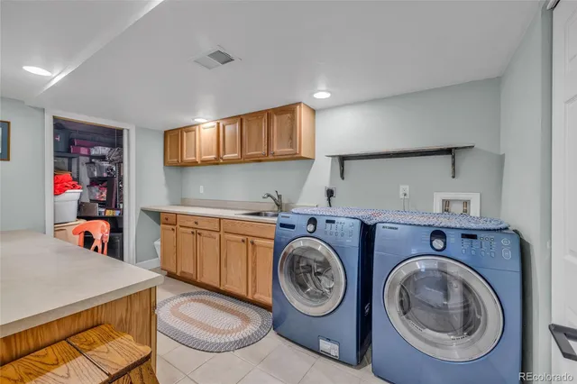 a view of a storage & utility room with sink dryer and washer