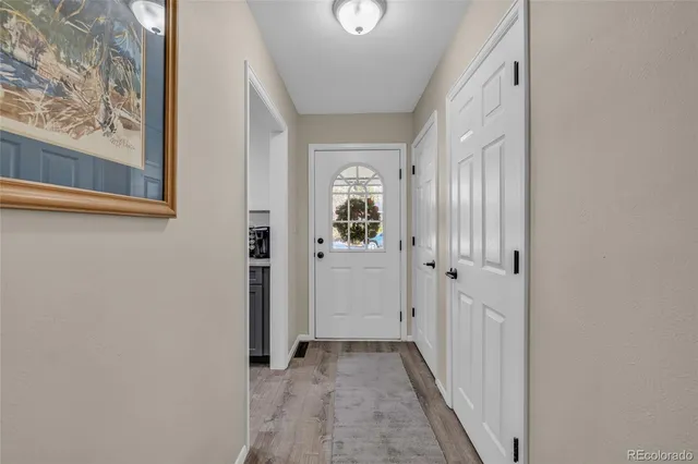 a view of a hallway with wooden floor and entryway