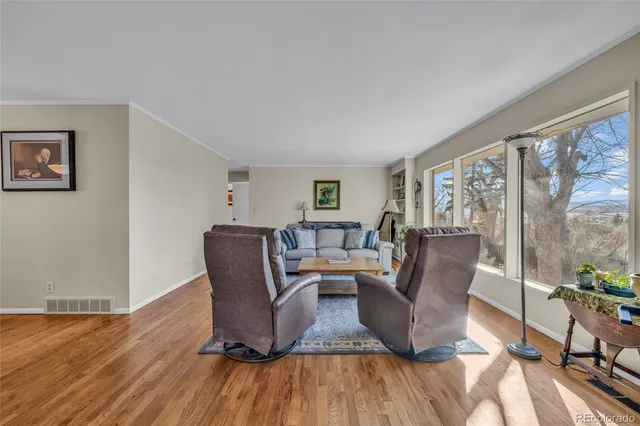 a living room with furniture a wooden floor and a potted plant