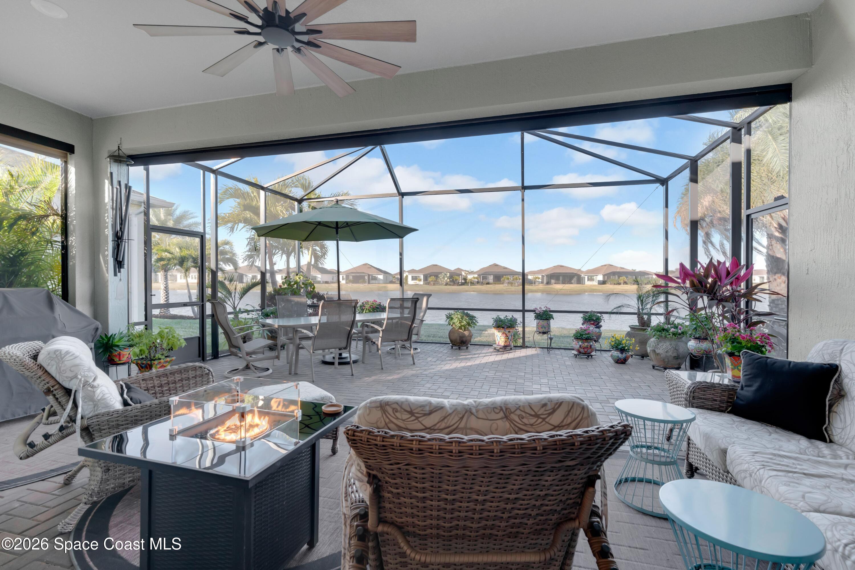a living room with furniture a chandelier and a floor to ceiling window