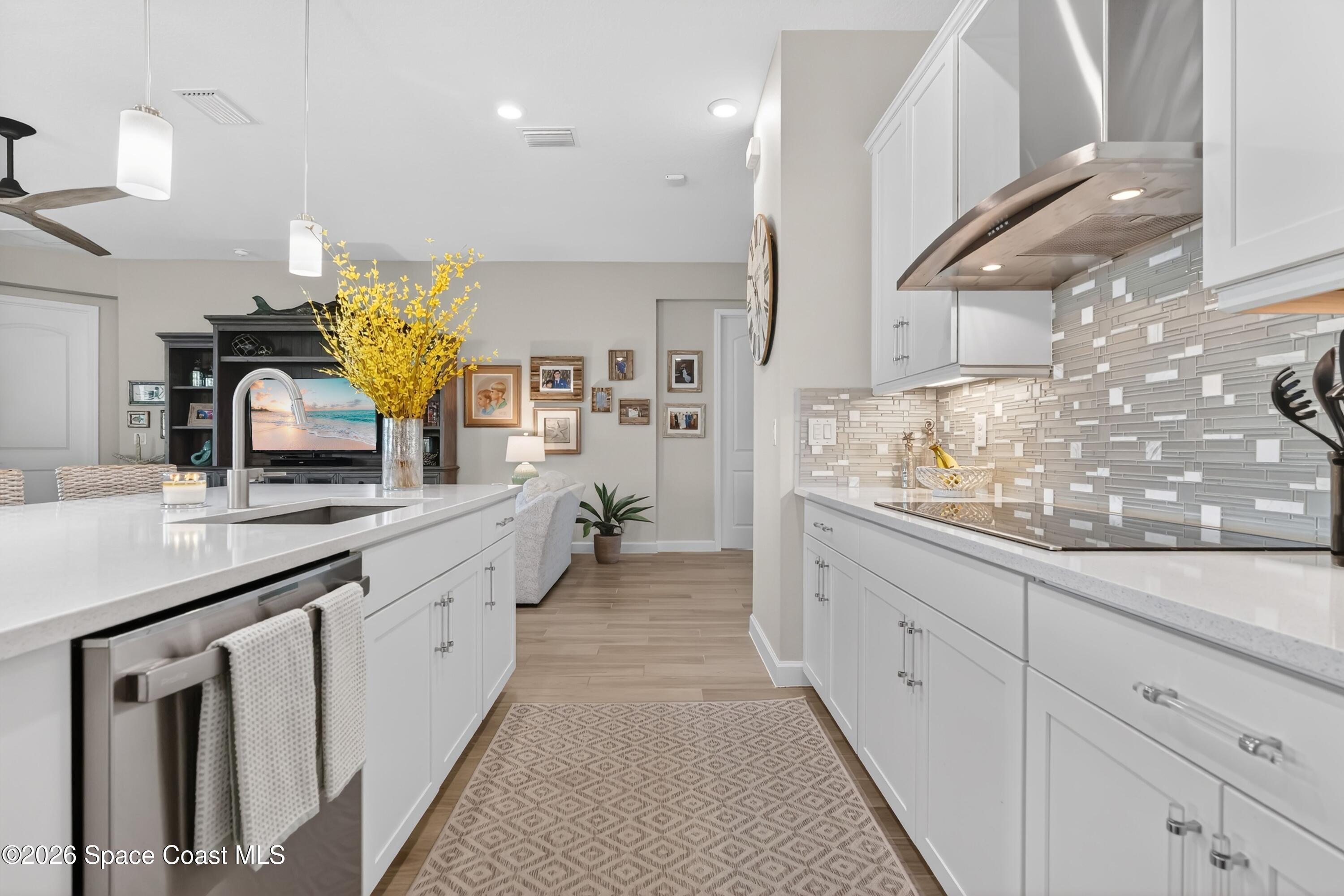 2819 Millennium Circle Melbourne, FL 32940 - Photo 11 of 39 a large white kitchen with a lot of counter space and wooden floor