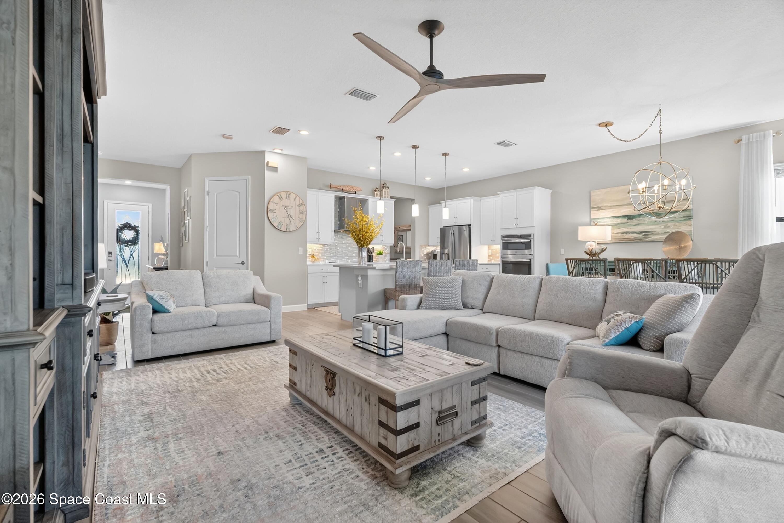 2819 Millennium Circle Melbourne, FL 32940 - Photo 4 of 39 a living room with furniture kitchen view and a chandelier