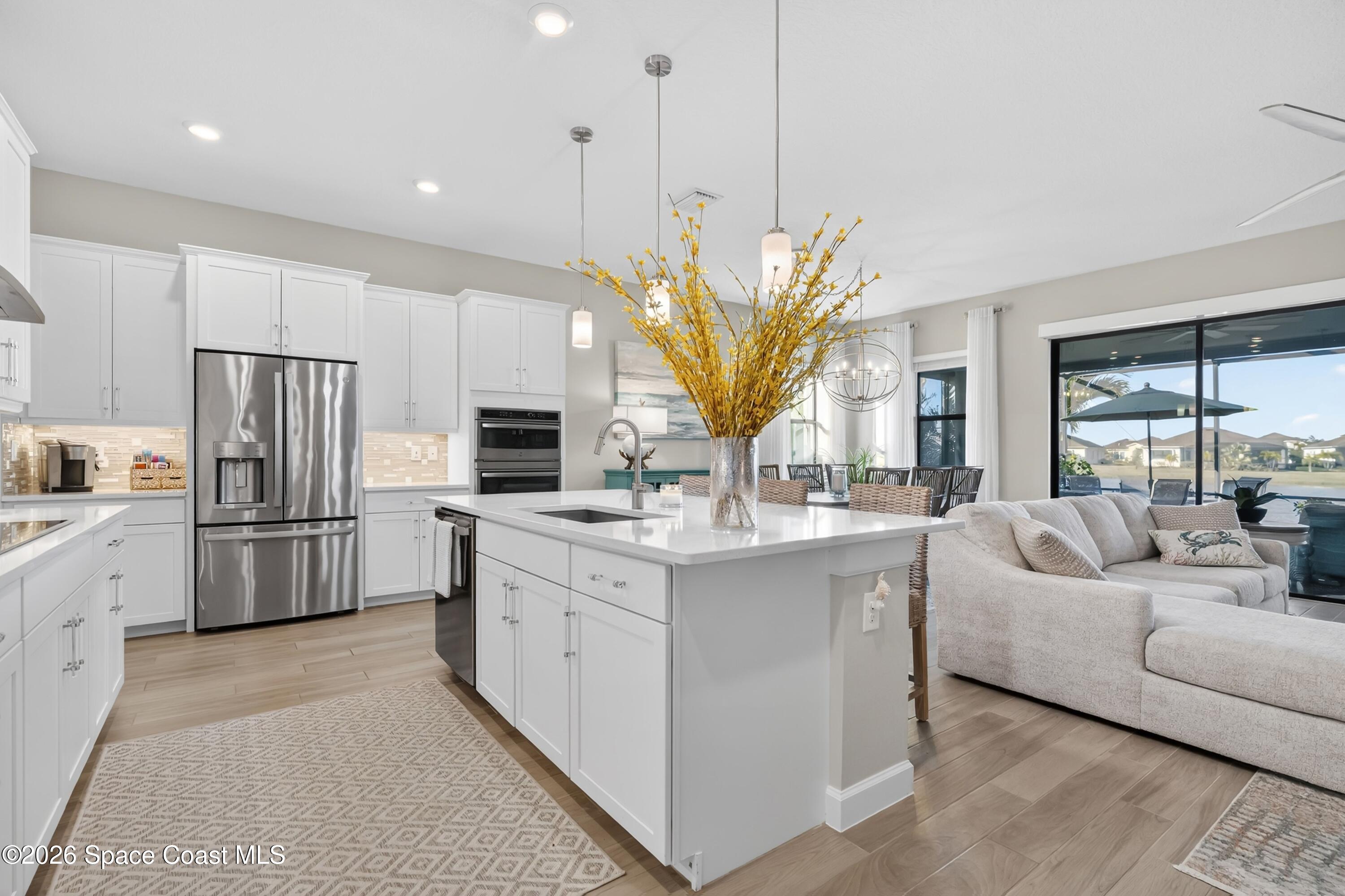 2819 Millennium Circle Melbourne, FL 32940 - Photo 6 of 39 a living room with stainless steel appliances granite countertop furniture a sink a kitchen island a stove and a refrigerator