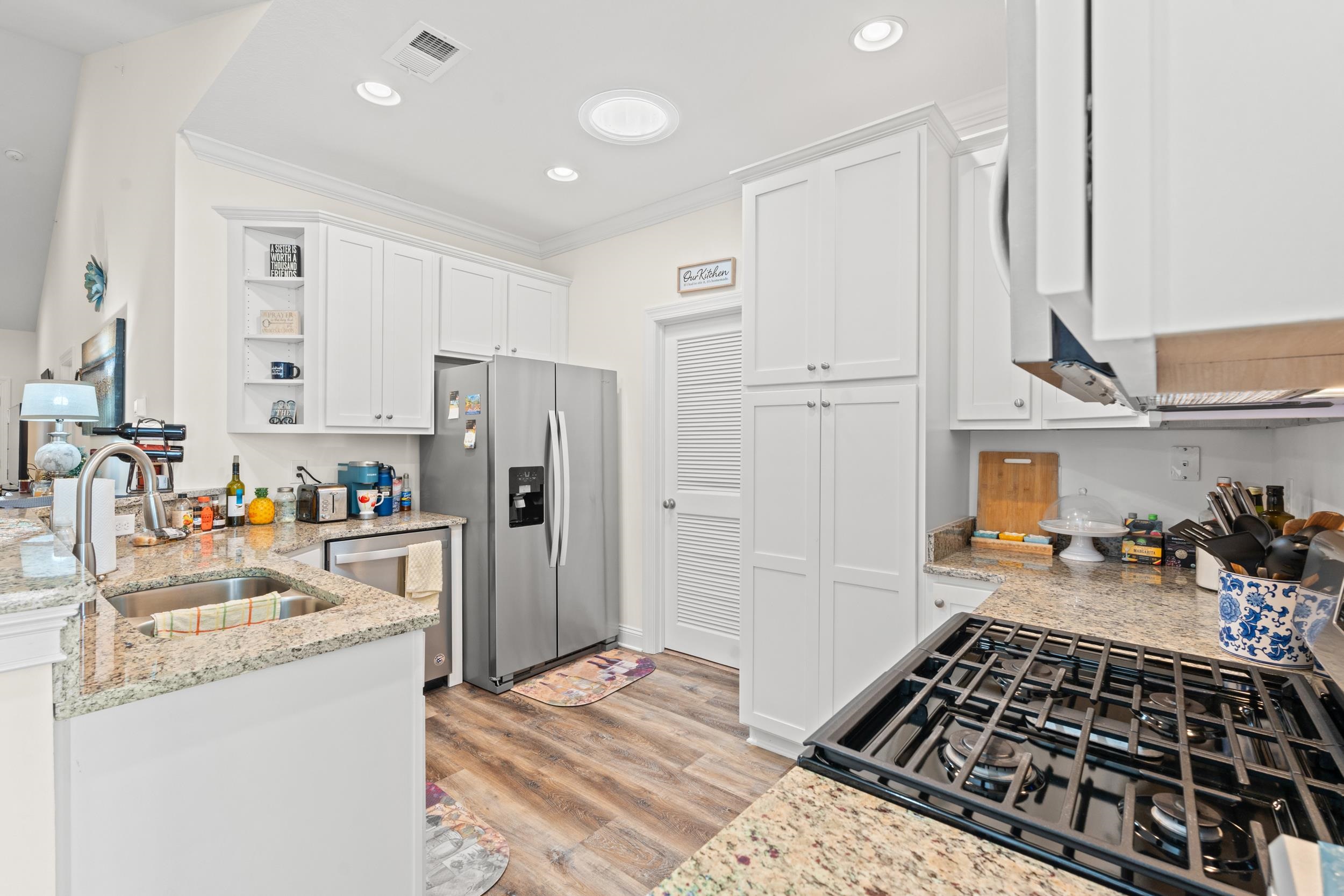 900 Jackline Place, Unit 202 Murrells Inlet, SC 29576 - Photo 18 of 39 Kitchen with stainless steel appliances, light stone countertops, white cabinetry, open shelves, and ornamental molding
