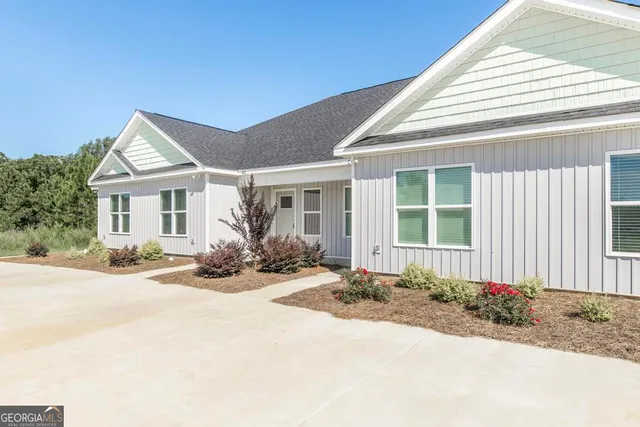 a front view of a house with a yard and potted plants