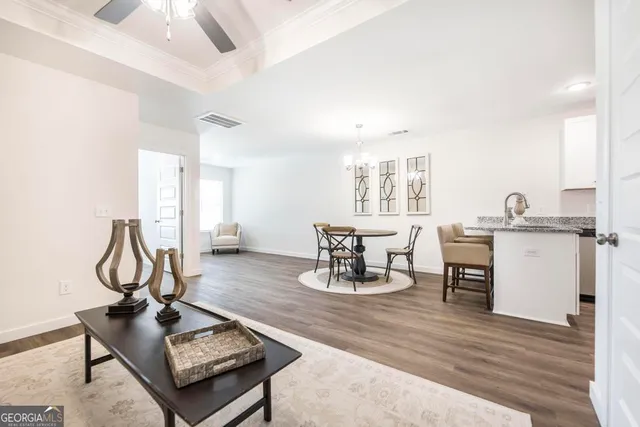 a living room with furniture a dining table and wooden floor