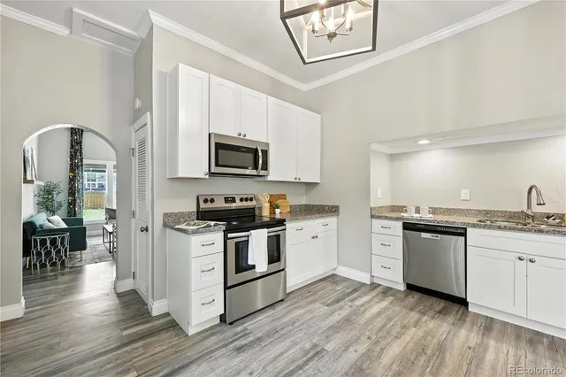 a kitchen with granite countertop a stove and cabinets