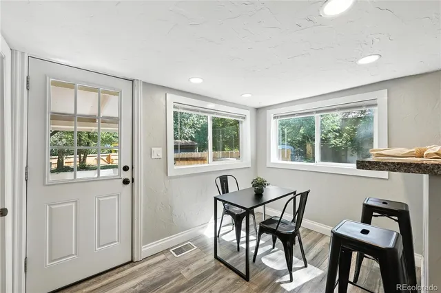 a view of a dining room with furniture a chandelier and wooden floor