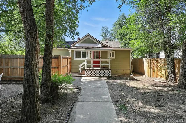 a view of a house with a tree in front of it