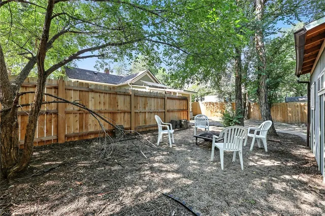 a view of a yard with large trees and a barn