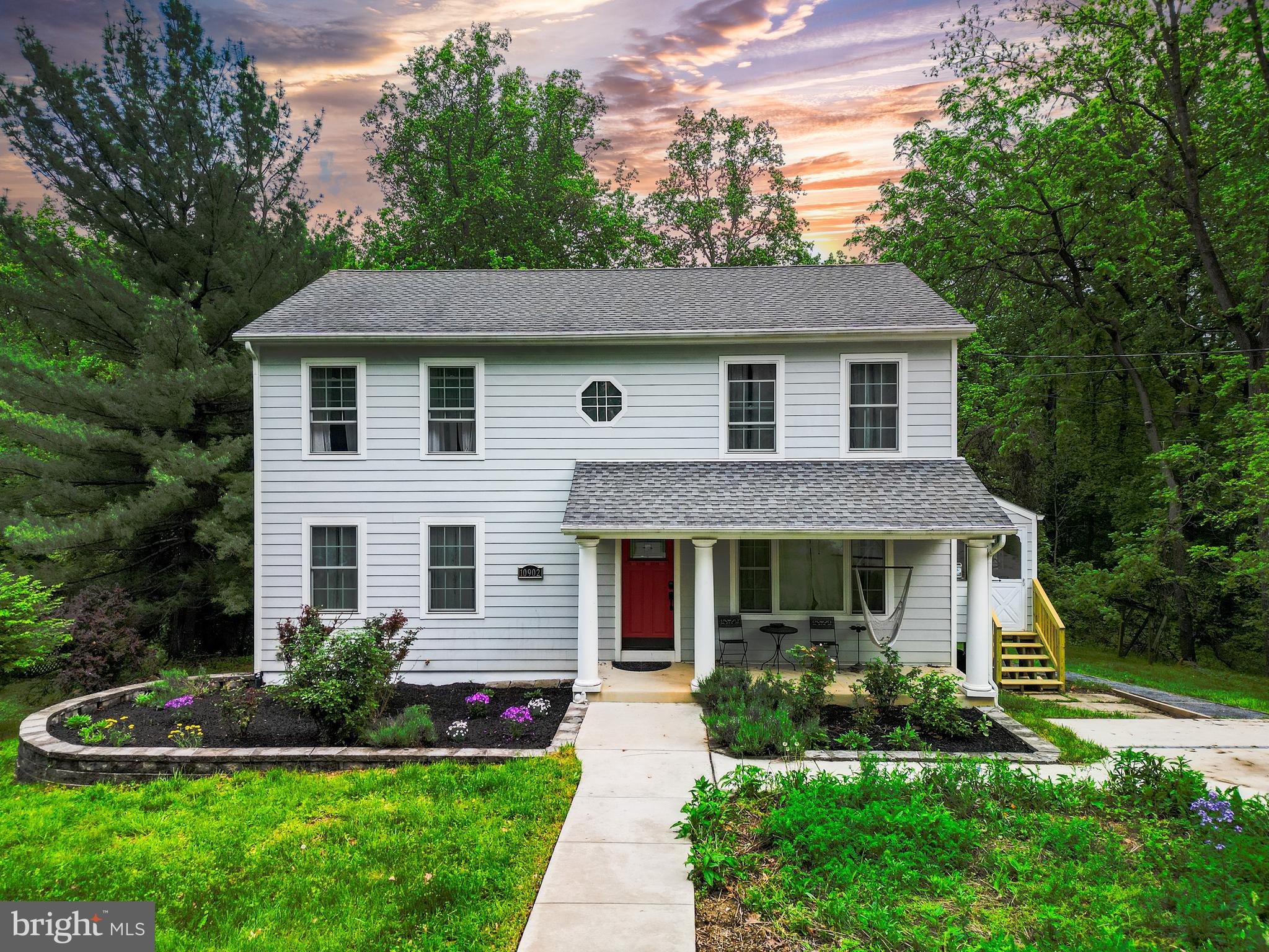 a front view of a house with a yard and trees