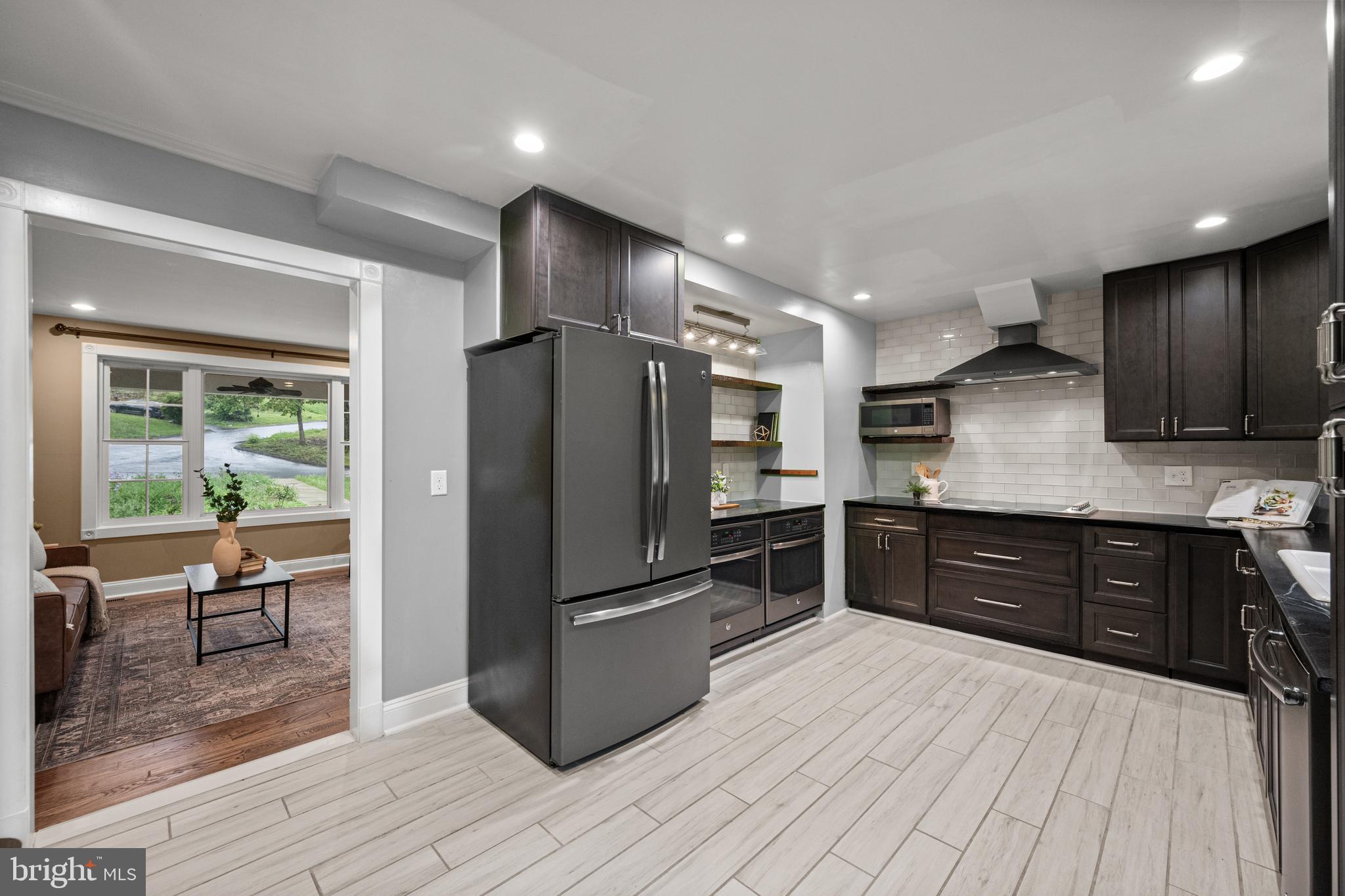 10902 Hammond Drive Laurel, MD 20723 - Photo 12 of 48 a kitchen with stainless steel appliances granite countertop a refrigerator a sink dishwasher a stove with wooden cabinets and wooden floor