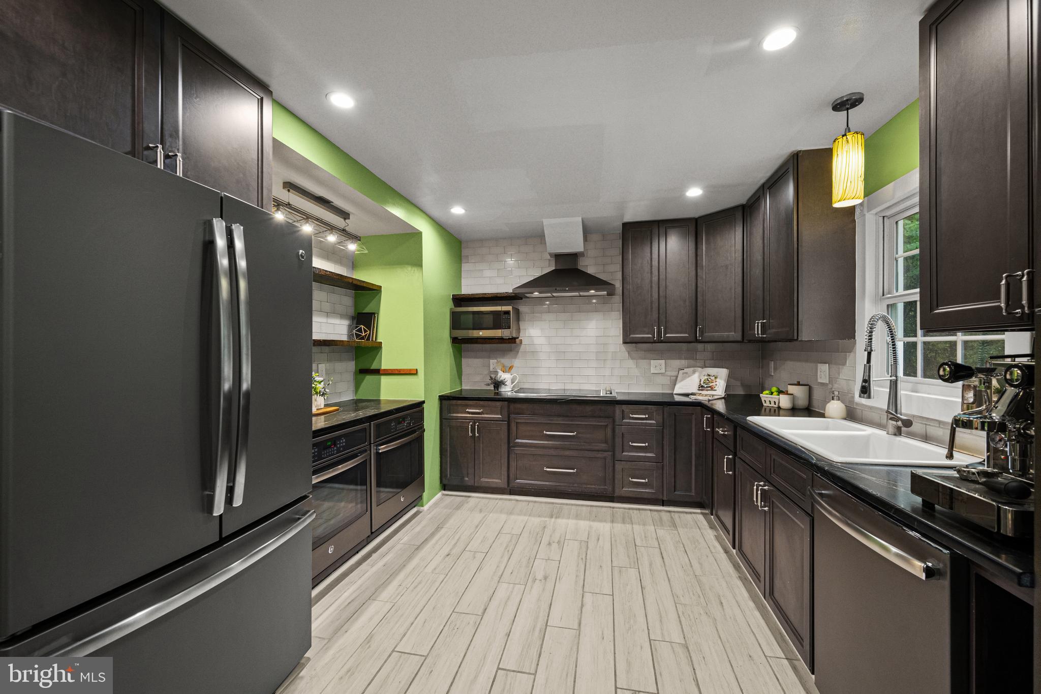10902 Hammond Drive Laurel, MD 20723 - Photo 9 of 48 a large kitchen with stainless steel appliances wooden cabinets and a stove top oven