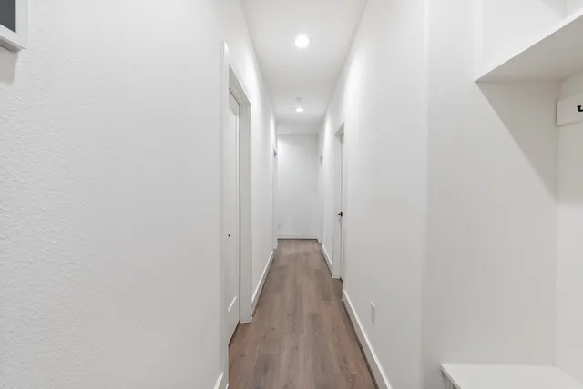 a view of a hallway with wooden floor