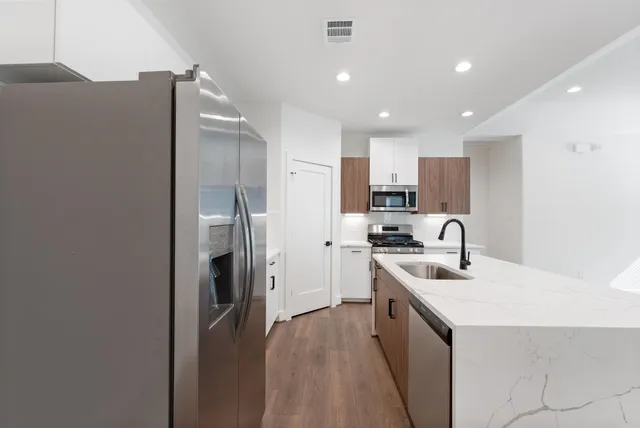 a kitchen with kitchen island a sink stove and refrigerator