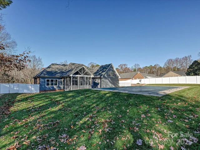 a view of a big house with a big yard and large trees