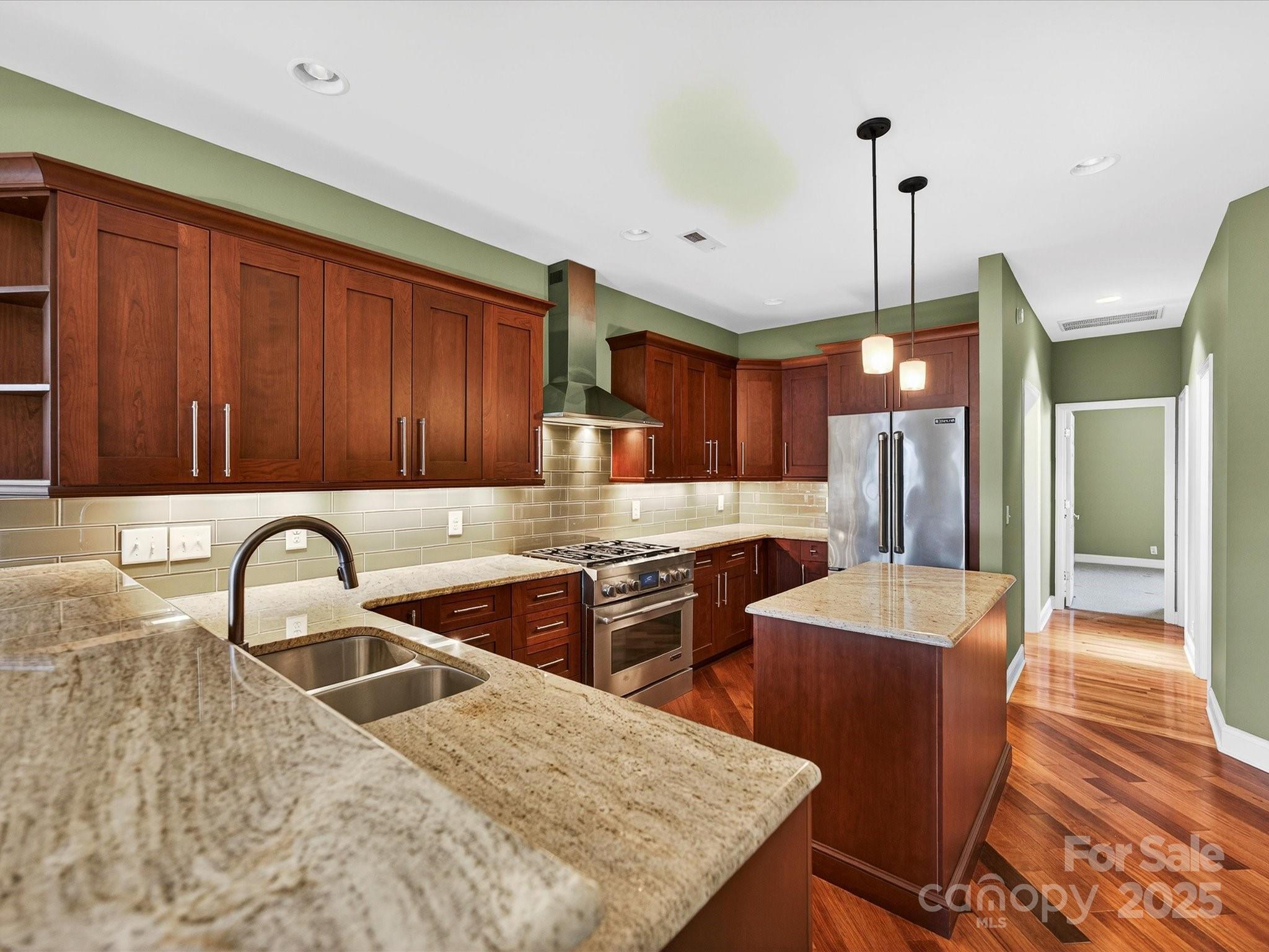 153 Collingswood Road Mooresville, NC 28117 - Photo 4 of 28 a kitchen with stainless steel appliances granite countertop a sink a stove and a wooden floors