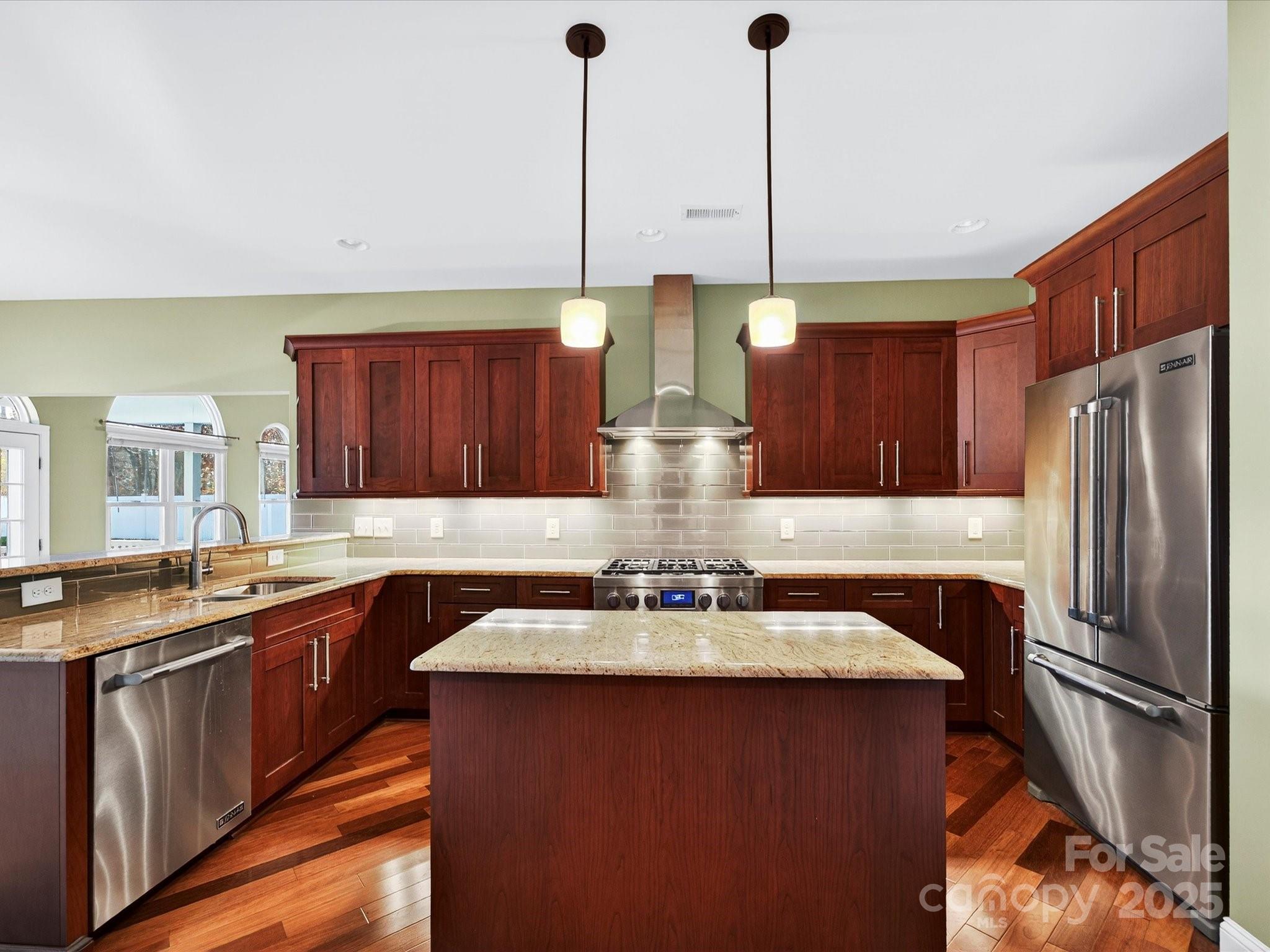 153 Collingswood Road Mooresville, NC 28117 - Photo 5 of 28 a kitchen with stainless steel appliances a sink a stove a refrigerator a center island and cabinets