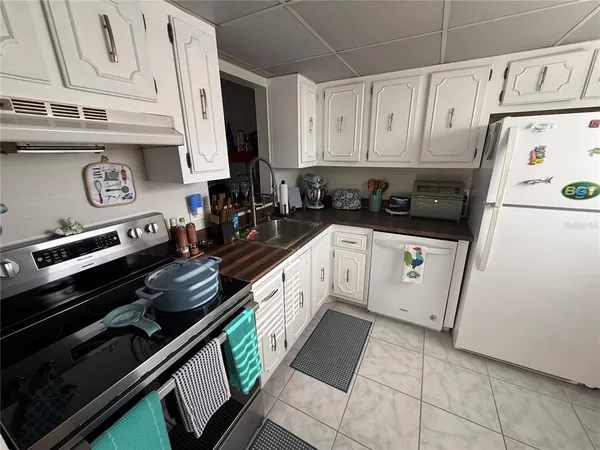 a kitchen with granite countertop a stove sink and cabinets