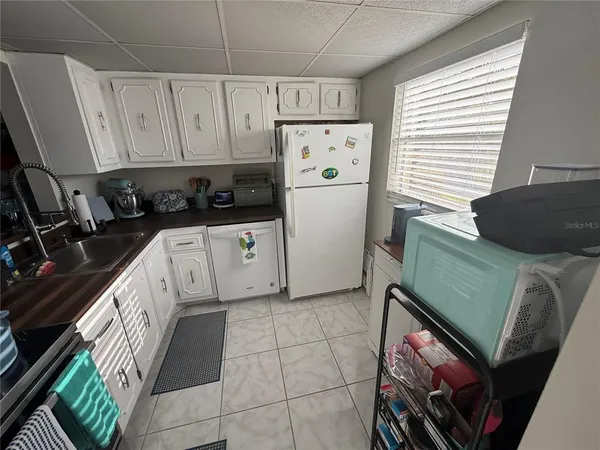 a kitchen with white cabinets and white appliances