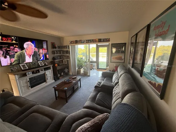 a living room with furniture a flat screen tv and a window