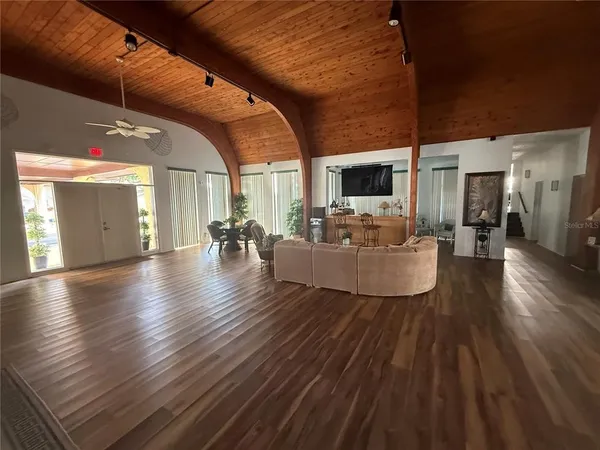 a living room with couches and a fireplace with wooden floor